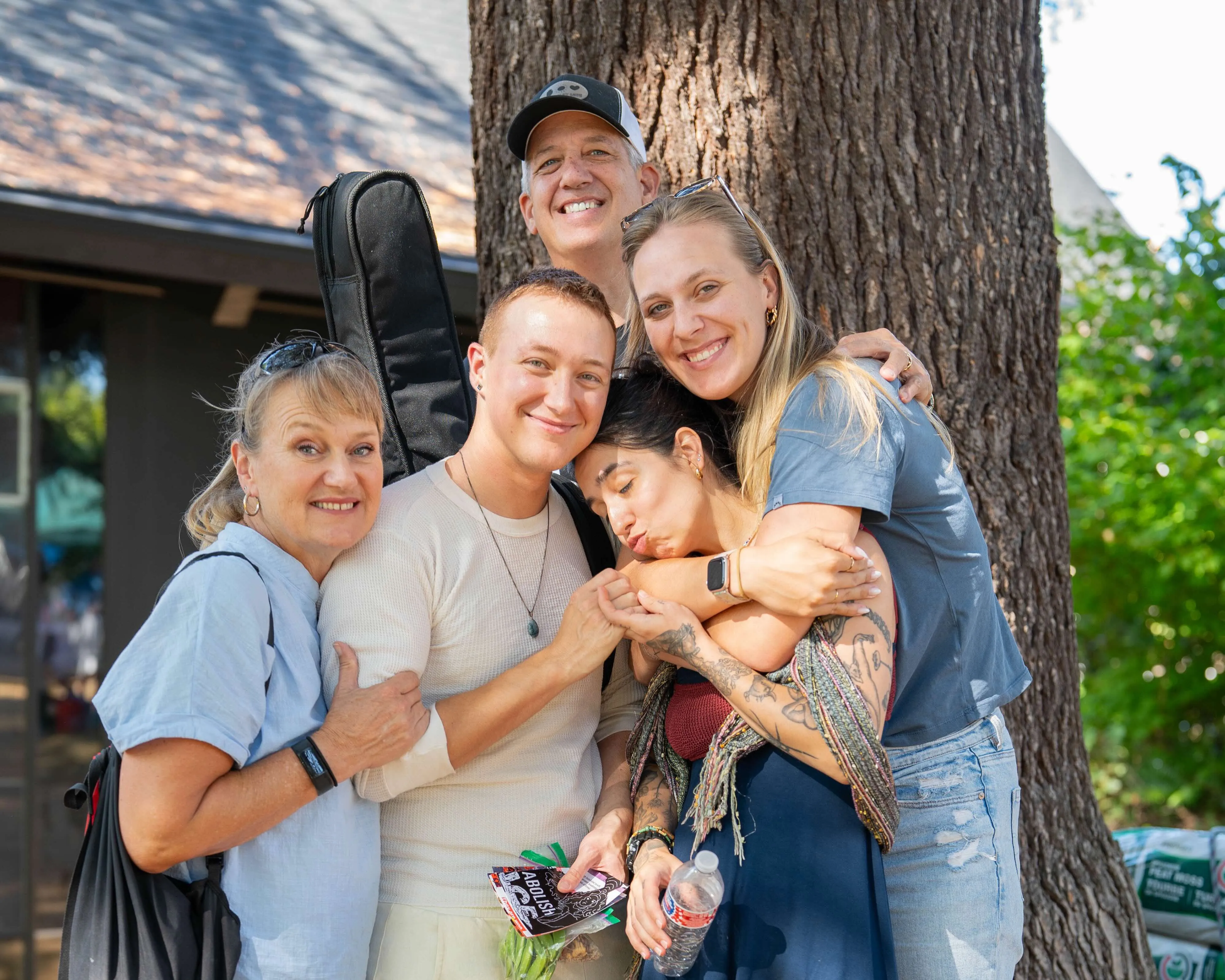Group of people embracing under a tree